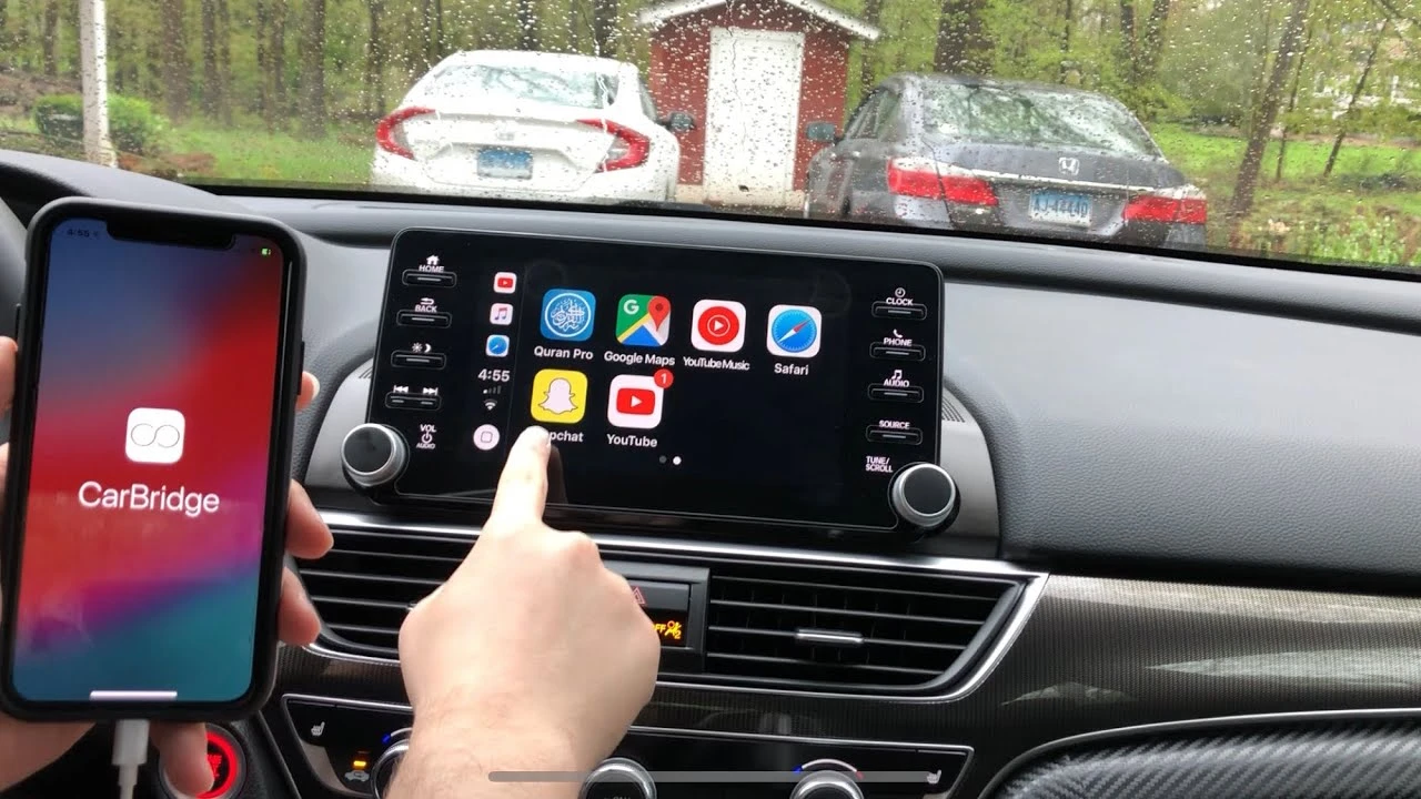 iPhone conectado ao CarPlay com o ícone do YouTube na tela do carro